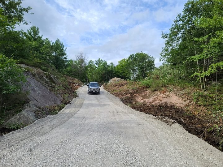 Gravel access road through a wooded property